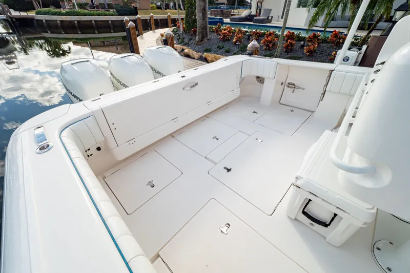 Slide: The Image of 2019 Intrepid 407 Cuddy boat deck with storage compartments and outboard engines. - 28