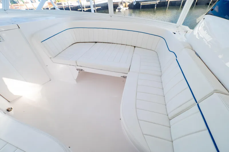 Slide: The Image of 2019 Intrepid 407 Cuddy boat interior with white cushioned seating and blue accents. - 3