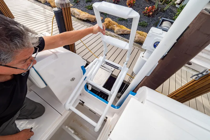 Slide: The Image of 2019 Intrepid 407 Cuddy boat ladder with person demonstrating access. - 32