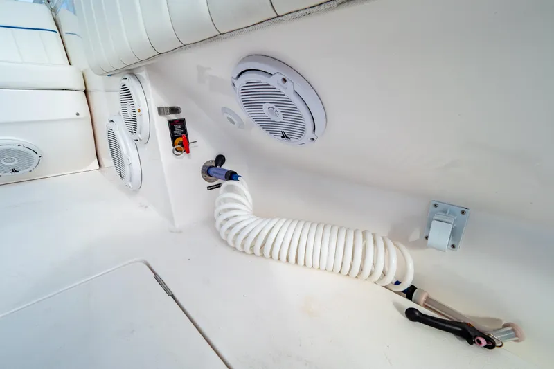 Slide: The Image of 2019 Intrepid 407 Cuddy boat interior with speakers and coiled hose. - 33