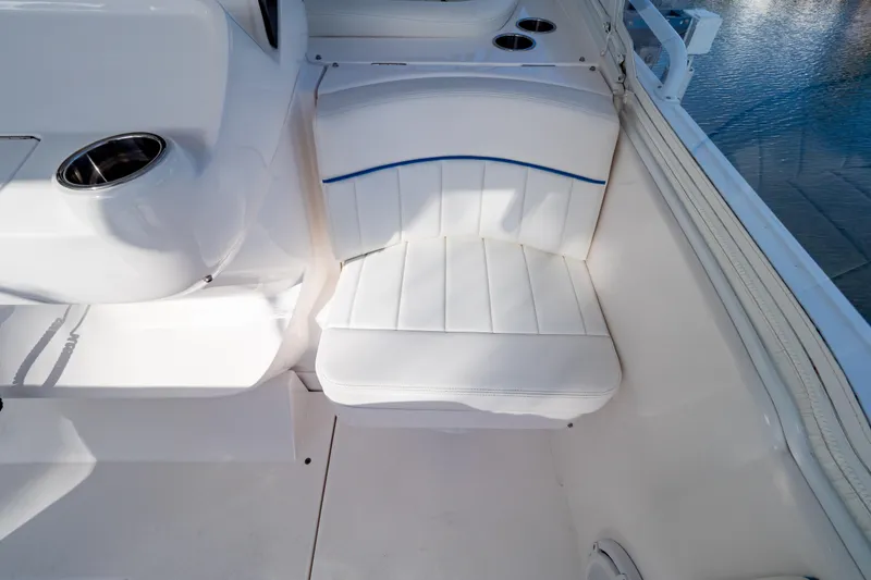 Slide: The Image of White seating area on 2019 Intrepid 407 Cuddy boat, featuring cup holders and sleek design. - 47