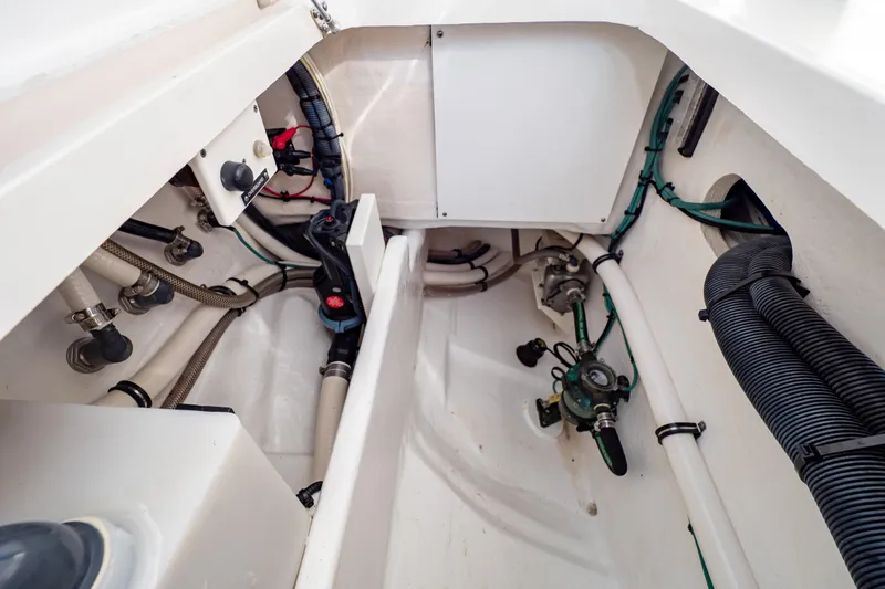 Slide: The Image of Interior view of 2019 Intrepid 407 Cuddy boat's engine compartment with visible wiring and hoses. - 50