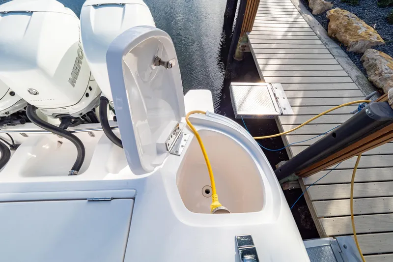 Slide: The Image of 2019 Intrepid 407 Cuddy boat with Mercury engines docked, featuring a yellow power cable. - 59