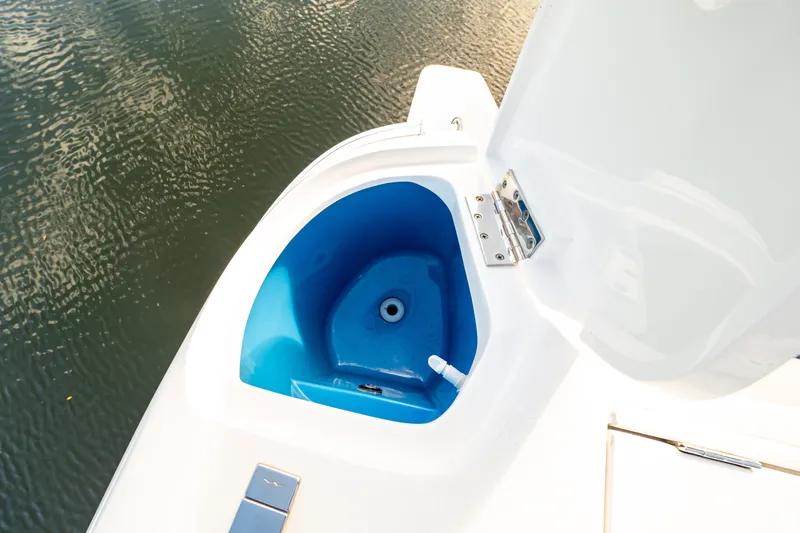 Slide: The Image of 2019 Intrepid 407 Cuddy boat with open storage compartment near water. - 60