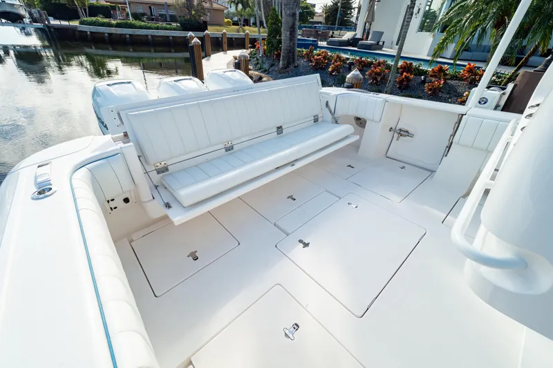 Slide: The Image of 2019 Intrepid 407 Cuddy boat interior with white seating and storage compartments. - 62