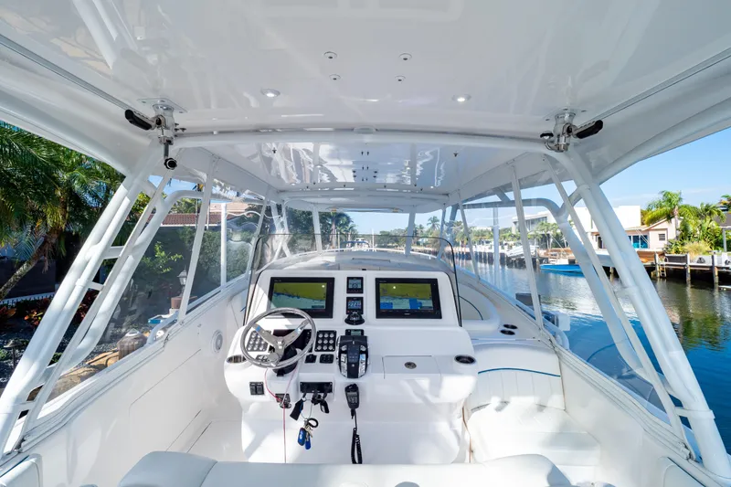 Slide: The Image of 2019 Intrepid 407 Cuddy boat cockpit with modern navigation system and waterfront view. - 64