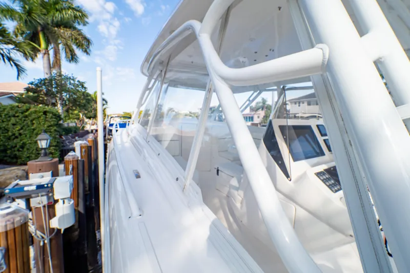 Slide: The Image of 2019 Intrepid 407 Cuddy boat docked, showcasing sleek design and modern navigation equipment. - 68