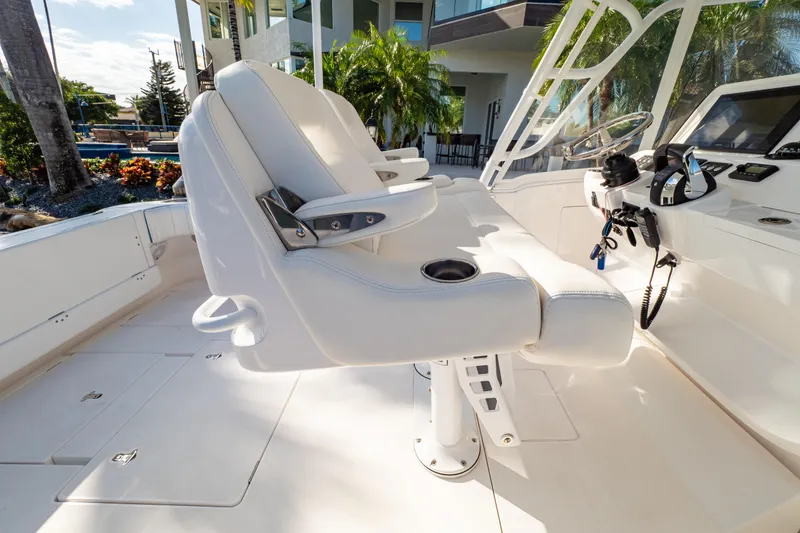 Slide: The Image of 2019 Intrepid 407 Cuddy boat interior with white seating and modern controls. - 71