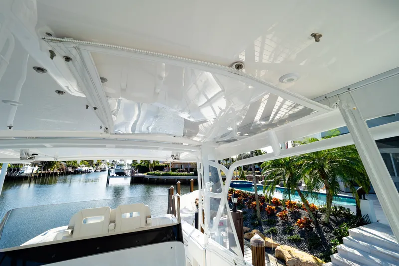 Slide: The Image of 2019 Intrepid 407 Cuddy boat interior with waterfront view and lush greenery. - 89