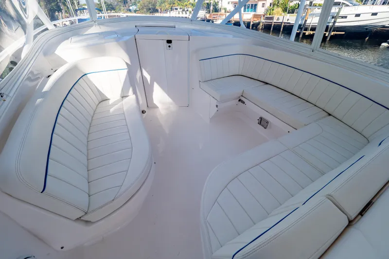 Slide: The Image of 2019 Intrepid 407 Cuddy boat interior with white cushioned seating and sleek design. - 92