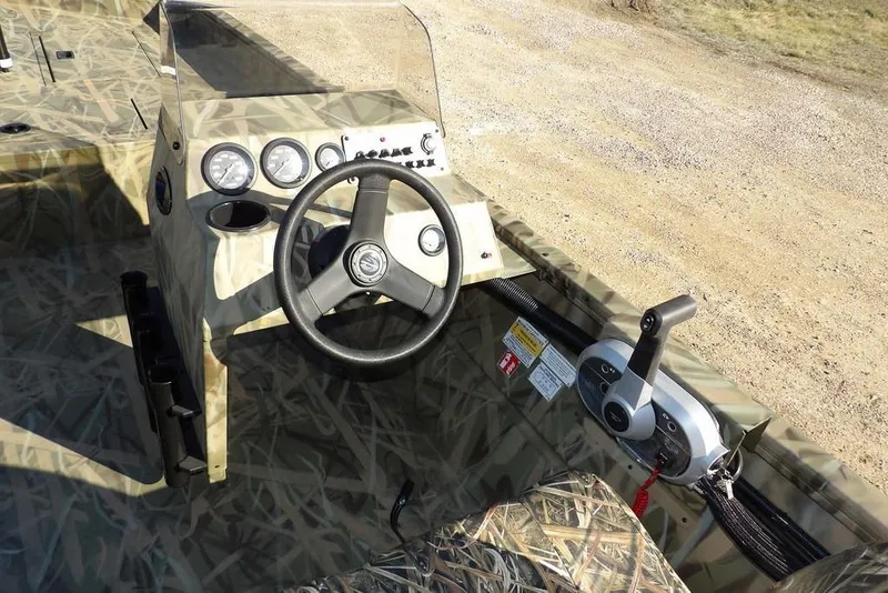 Slide: The Image of 2026 Crestliner 1860 Retriever SC boat interior with camo design and steering console. - 20