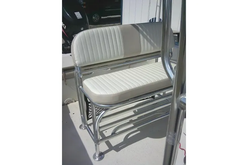 Slide: The Image of 2013 Carolina Skiff 218 DLV boat seat with white upholstery and metal frame. - 16