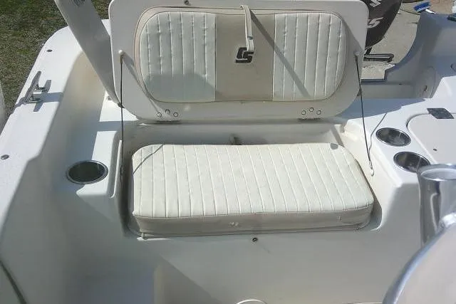 Slide: The Image of 2013 Carolina Skiff 218 DLV boat interior with white cushioned seating and cup holders. - 21