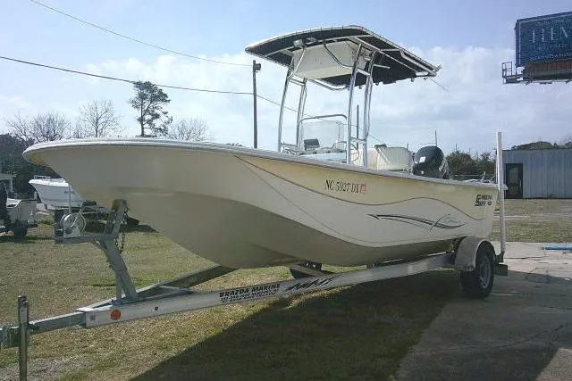 Slide: The Image of 2013 Carolina Skiff 218 DLV boat on trailer, parked outdoors. - 3