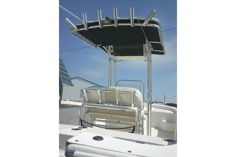 Slide: The Image of 2013 Carolina Skiff 218 DLV boat with T-top and rod holders under clear sky. - 9