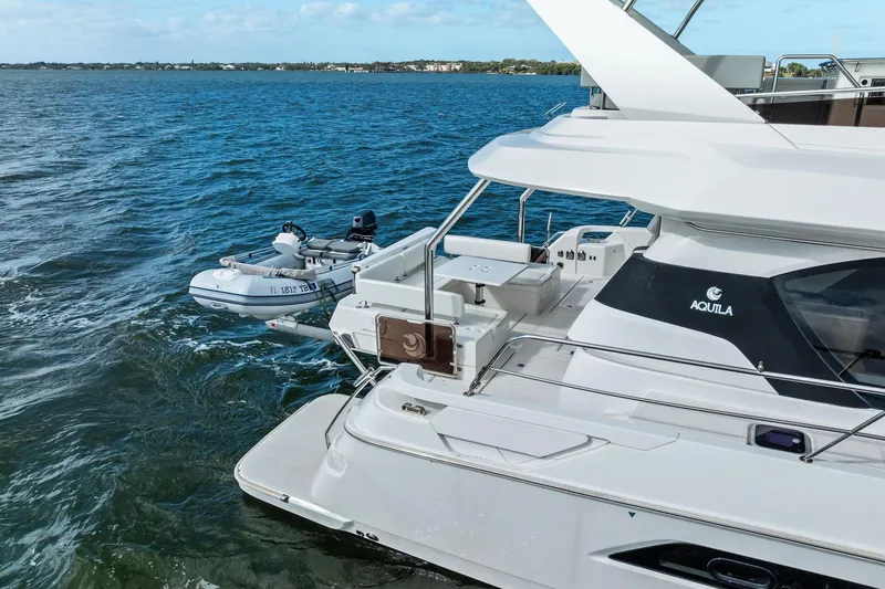 Slide: The Image of Aquila 44 Yacht 2021 on water with attached dinghy, showcasing luxury design. - 11