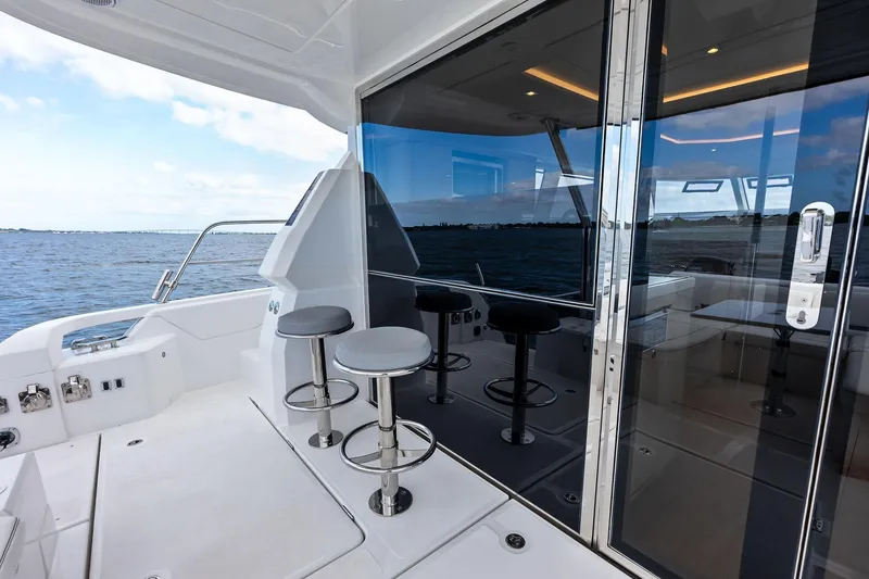 Slide: The Image of Aquila 44 Yacht 2021, sleek deck with bar stools and ocean view. - 15