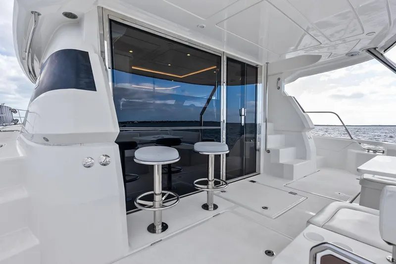 Slide: The Image of Luxurious 2021 Aquila 44 Yacht deck with bar stools and ocean view. - 16