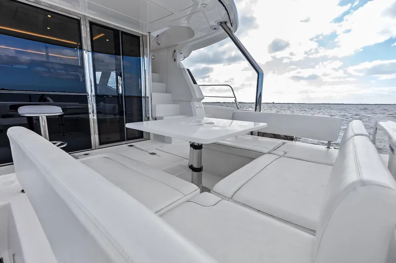 Slide: The Image of Luxurious 2021 Aquila 44 Yacht interior with white seating and ocean view. - 17