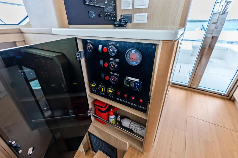 Slide: The Image of Control panel inside 2021 Aquila 44 Yacht, featuring gauges and switches, with a view of the deck. - 46