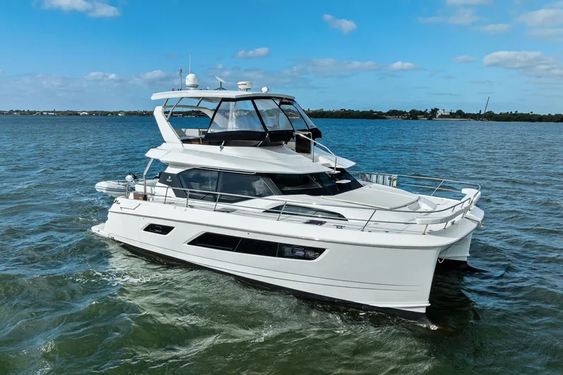 Slide: The Image of 2021 Aquila 44 Yacht cruising on open water under a clear blue sky. - 5