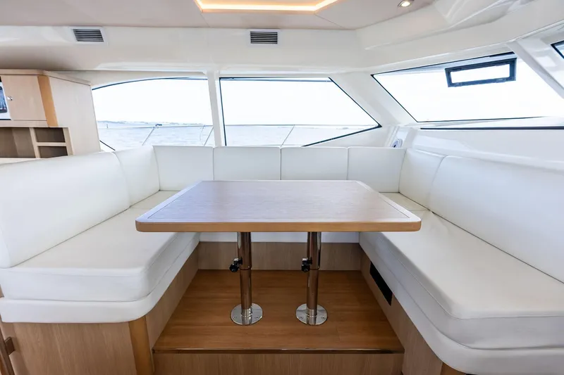 Slide: The Image of Interior of 2021 Aquila 44 Yacht with white seating and wooden table. - 50