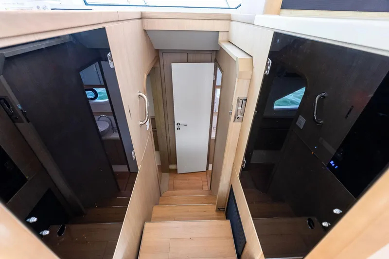 Slide: The Image of Interior view of 2021 Aquila 44 Yacht, featuring wooden stairs and cabin doors. - 58