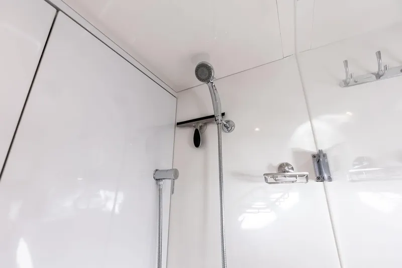 Slide: The Image of Shower area in 2021 Aquila 44 Yacht with modern fixtures and white walls. - 76