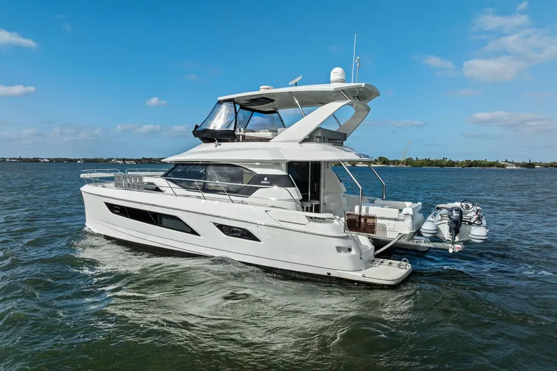 Slide: The Image of 2021 Aquila 44 Yacht cruising on open water under a clear blue sky. - 9