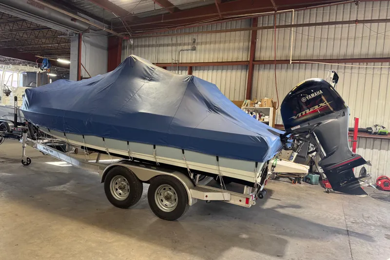 Slide: The Image of 2024 Skeeter SX210 boat with cover and Yamaha outboard motor in a garage. - 14