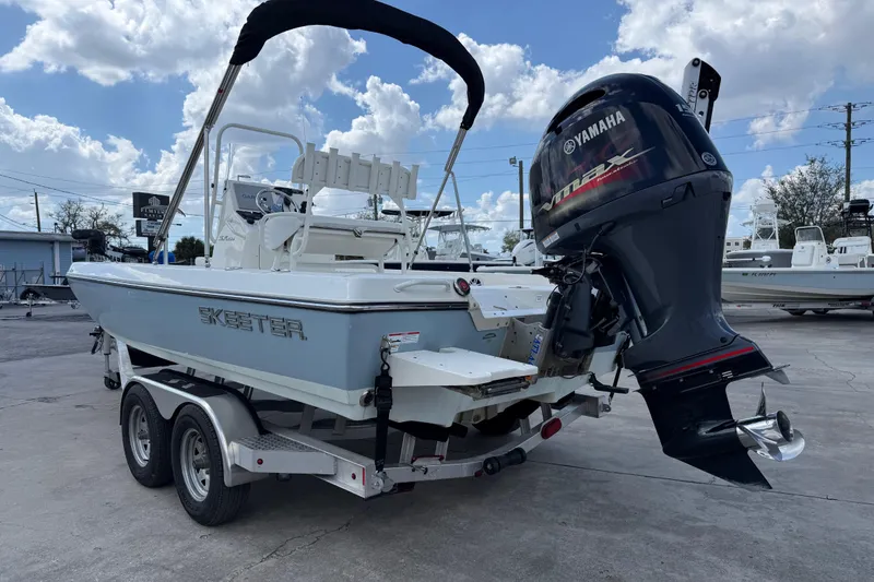 Slide: The Image of 2024 Skeeter SX210 boat with Yamaha outboard motor on a trailer, under a cloudy sky. - 4
