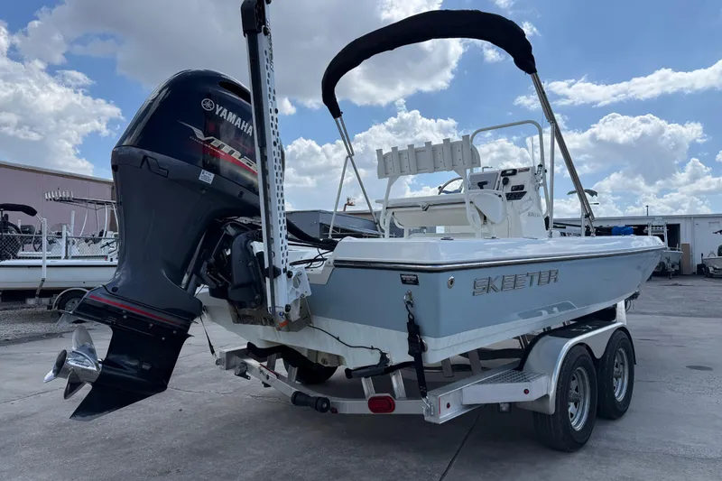 Slide: The Image of 2024 Skeeter SX210 boat on trailer with Yamaha outboard motor, parked outdoors. - 5