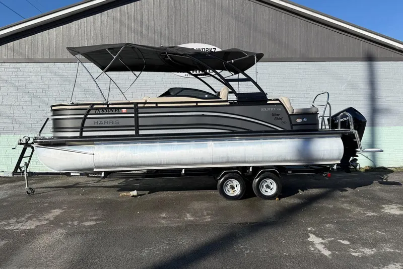 The Image of 2019 Harris Solstice DC 230 pontoon boat on trailer, parked outdoors. - 1