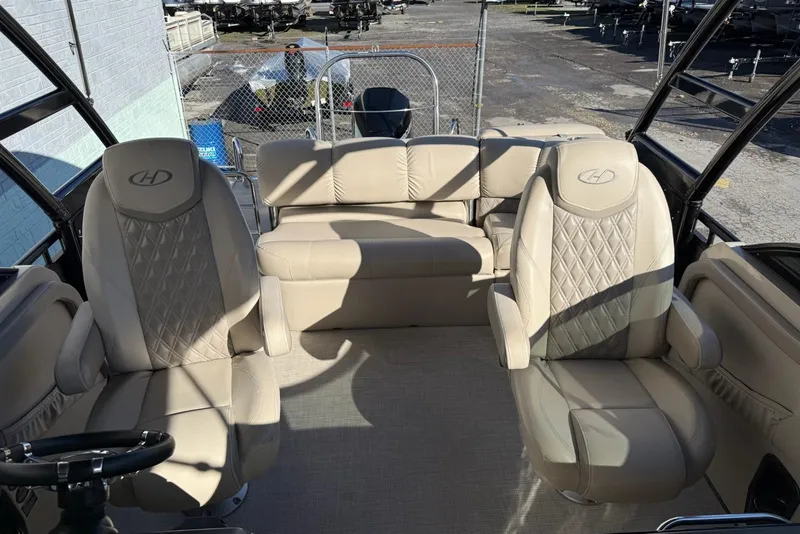 Slide: The Image of 2019 Harris Solstice DC 230 boat interior with beige seating and steering wheel. - 7