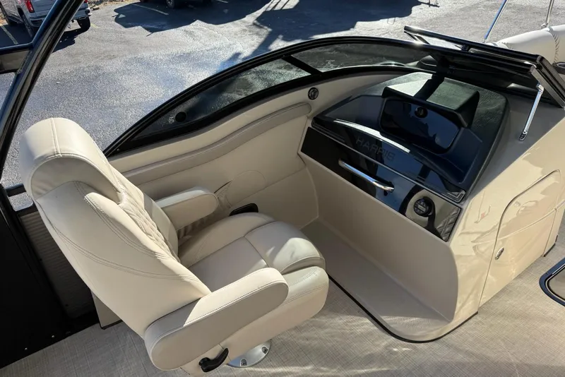 Slide: The Image of 2019 Harris Solstice DC 230 boat interior with beige captain's chair and sleek dashboard. - 9