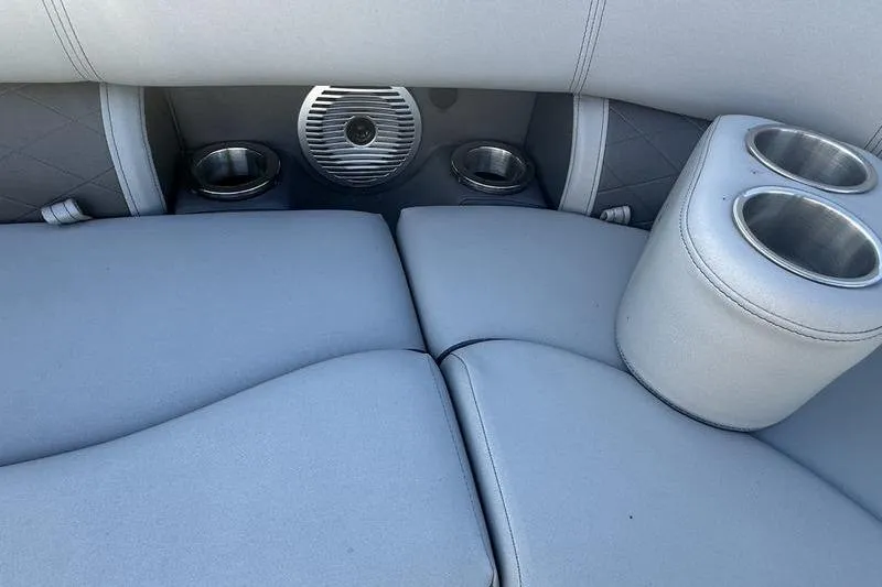 Slide: The Image of 2021 Bennington 23 LSB boat interior with gray seating, cup holders, and speaker. - 10
