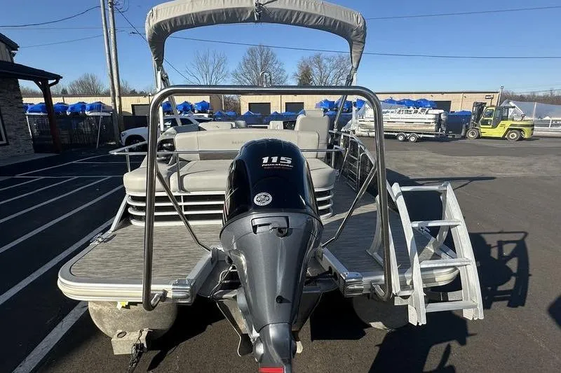 Slide: The Image of 2021 Bennington 23 LSB pontoon boat with 115 HP engine, parked outdoors. - 6