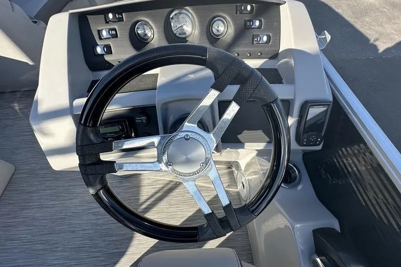 Slide: The Image of Steering wheel and dashboard of 2021 Bennington 23 LSB boat, featuring gauges and controls. - 9