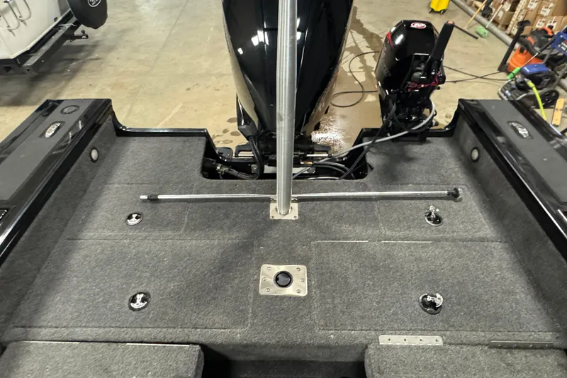 Slide: The Image of 2020 Tracker Targa V-19 Combo Tournament Edition boat interior with motor and carpeted deck. - 23