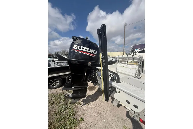 Slide: The Image of 2019 Shoalwater 20 Catamaran with Suzuki outboard motor, parked outdoors. - 10