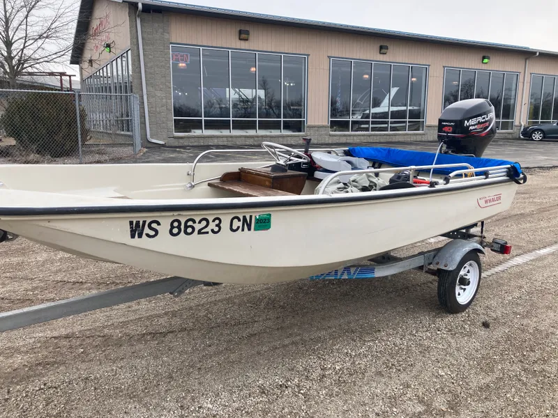 Slide: The Image of 1989 Boston Whaler 13 Sport boat on trailer in front of building. - 10