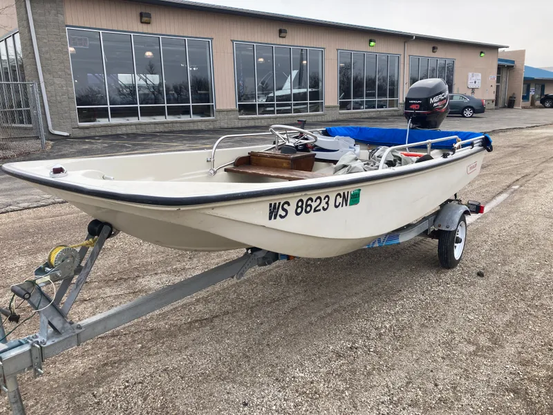 Slide: The Image of 1989 Boston Whaler 13 Sport boat on trailer in front of building. - 9