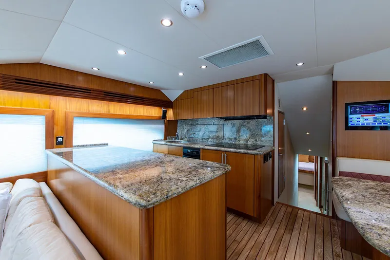 Slide: The Image of Interior of 2006 Hatteras 64 Convertible yacht with modern kitchen and wood finishes. - 12