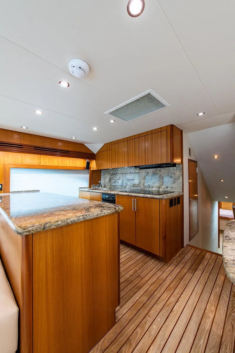 Slide: The Image of Interior of 2006 Hatteras 64 Convertible yacht with wooden cabinetry and modern lighting. - 14