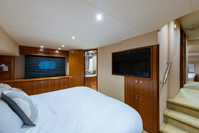 Slide: The Image of Interior of 2006 Hatteras 64 Convertible yacht bedroom with TV and wooden cabinetry. - 19