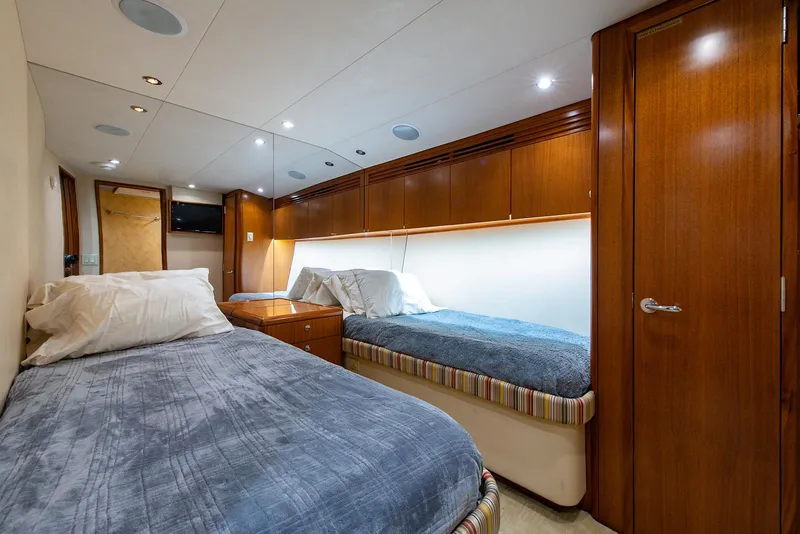 Slide: The Image of Interior of 2006 Hatteras 64 Convertible yacht with twin beds and wooden cabinetry. - 27