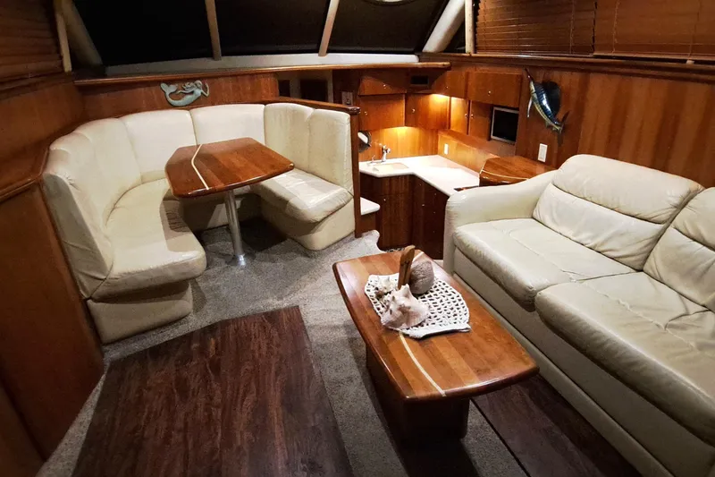 Slide: The Image of Luxurious interior of 2000 Silverton 42 Convertible yacht with cozy seating and elegant wood finishes. - 10