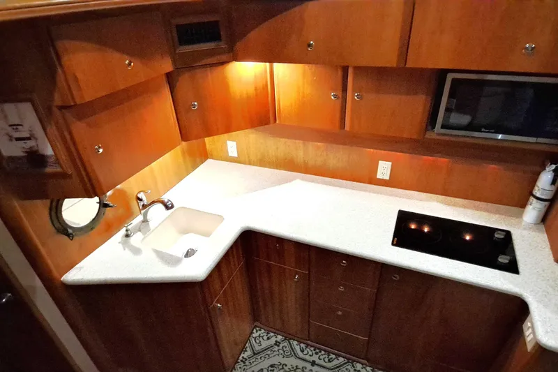 Slide: The Image of 2000 Silverton 42 Convertible yacht kitchen with wooden cabinets and modern appliances. - 12