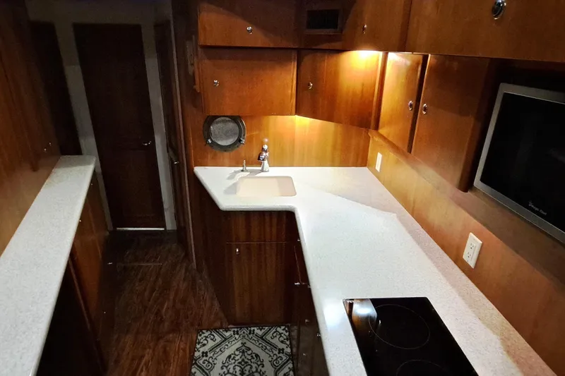 Slide: The Image of 2000 Silverton 42 Convertible yacht kitchen with wood cabinetry and modern appliances. - 13