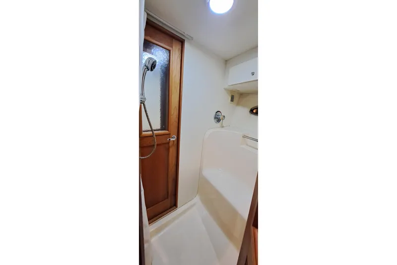 Slide: The Image of Shower area in 2000 Silverton 42 Convertible yacht with wooden door and white interior. - 15